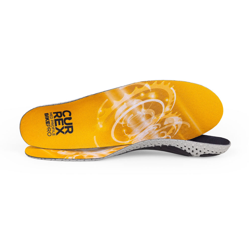Vue d'une paire de semelles BIKEPRO jaunes à profil moyen, l'une debout sur le côté pour montrer le haut de la semelle, la deuxième semelle placée à l'avant montrant son profil alors que le talon est face à la direction opposée #1-choix-de-son-profil_med
