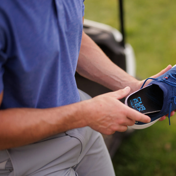 Homme mettant des semelles CURREX GOLFPRO dans sa chaussure sur le parcours de golf #1-choisir-son-profil_low
